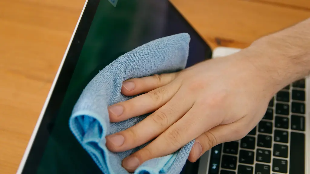 Ofis temizliğinde dizüstü bilgisayar ve çalışma masasının mikrofiber bezle silinmesi